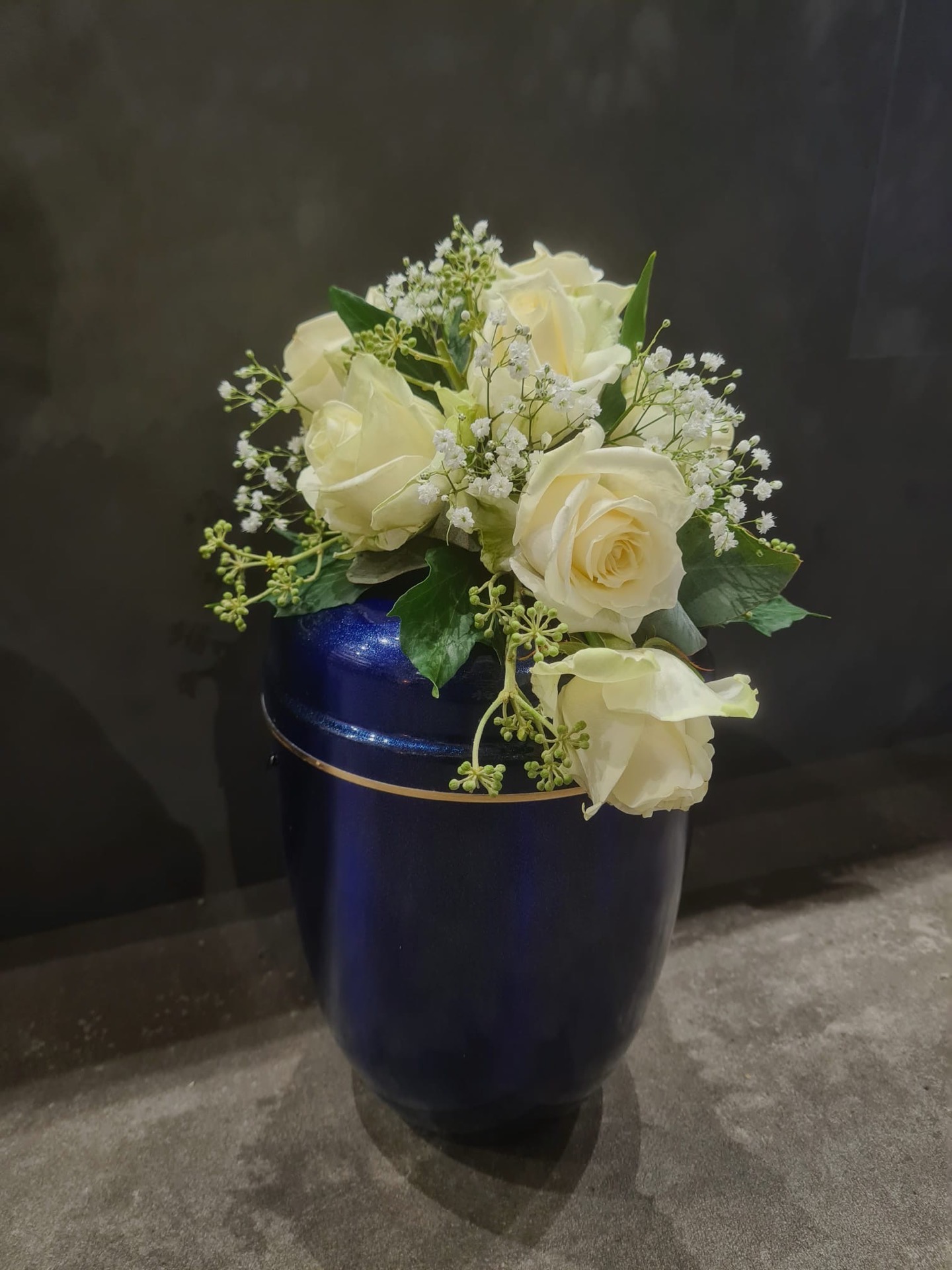 Tischgesteck Trauerfeier – weiße Rosen in blauer Vase